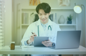 Man working in a clinical field while using a tablet and computer.